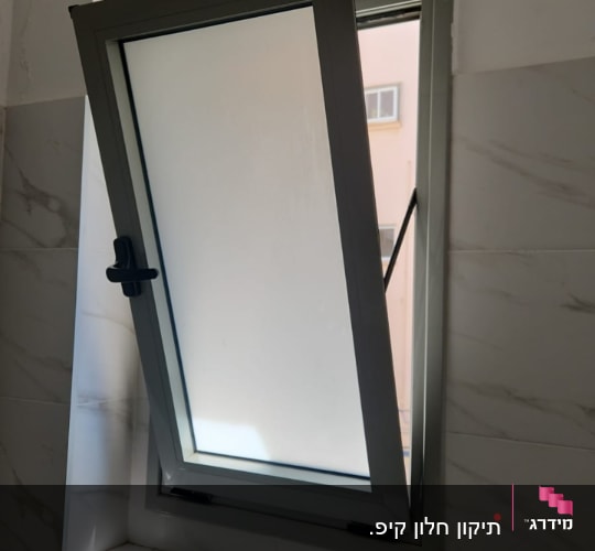 חלון פתוח עם מסגרת מתכת בחדר אמבטיה